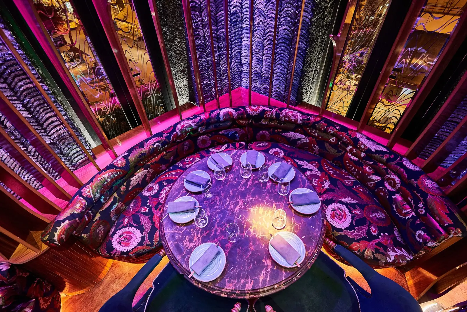 Round table in a magenta-lit booth