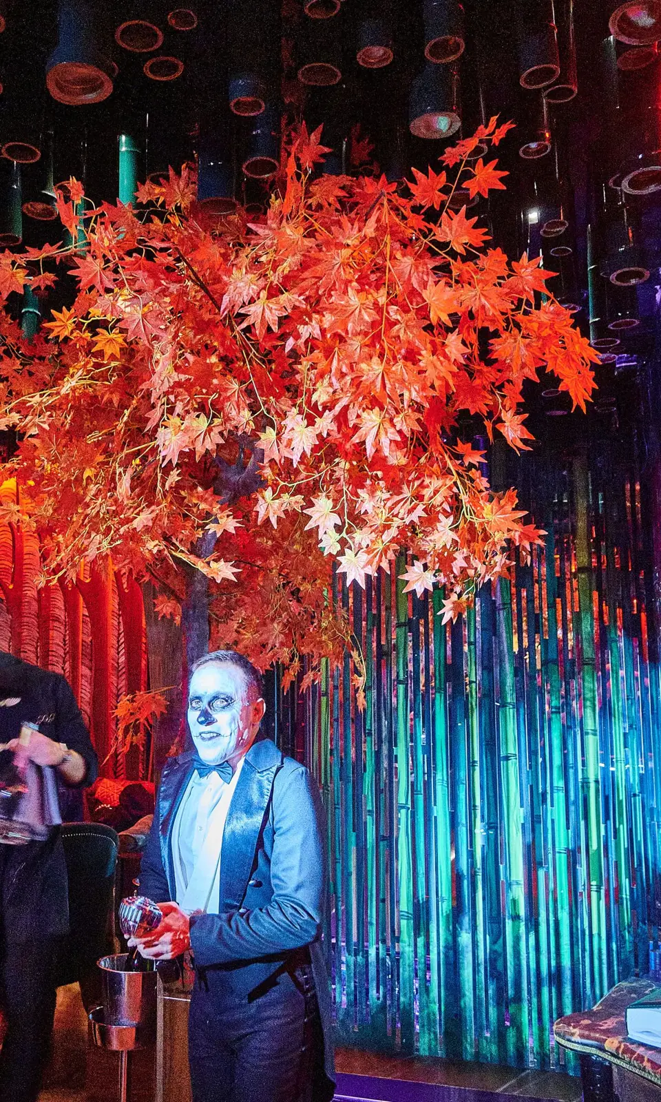 Performer in skull make-up beneath the maple tree